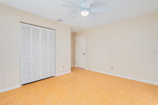 unfurnished bedroom with baseboards, a ceiling fan, visible vents, and a closet