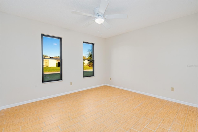 empty room with ceiling fan, baseboards, and light wood finished floors