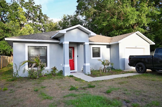 ranch-style home featuring stucco siding, fence, roof with shingles, and a garage