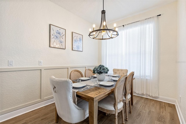 dining room with baseboards, wood finished floors, a chandelier, and a wainscoted wall