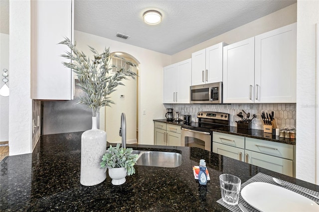 kitchen with visible vents, white cabinetry, stainless steel appliances, and a sink