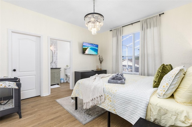 bedroom featuring connected bathroom, baseboards, a chandelier, and light wood-type flooring
