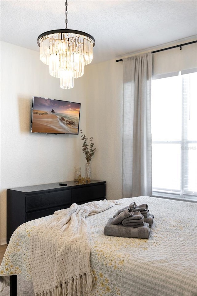 bedroom with a chandelier and a textured ceiling
