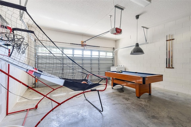 interior space with concrete block wall, pool table, concrete floors, and a textured ceiling