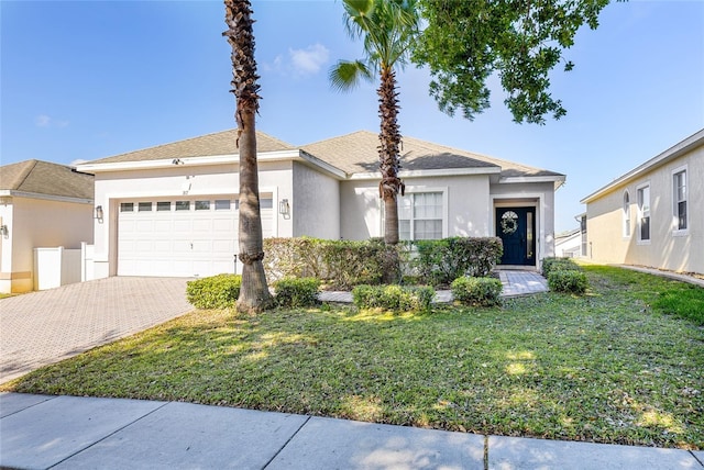 view of front of home featuring an attached garage, a front yard, decorative driveway, and stucco siding