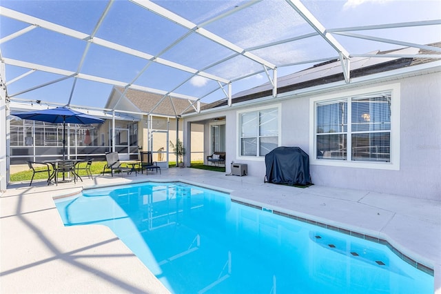 pool featuring glass enclosure, grilling area, and a patio