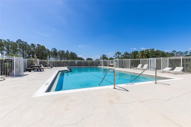 pool featuring fence and a patio area
