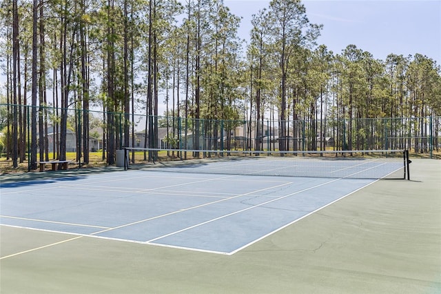 view of tennis court featuring community basketball court and fence
