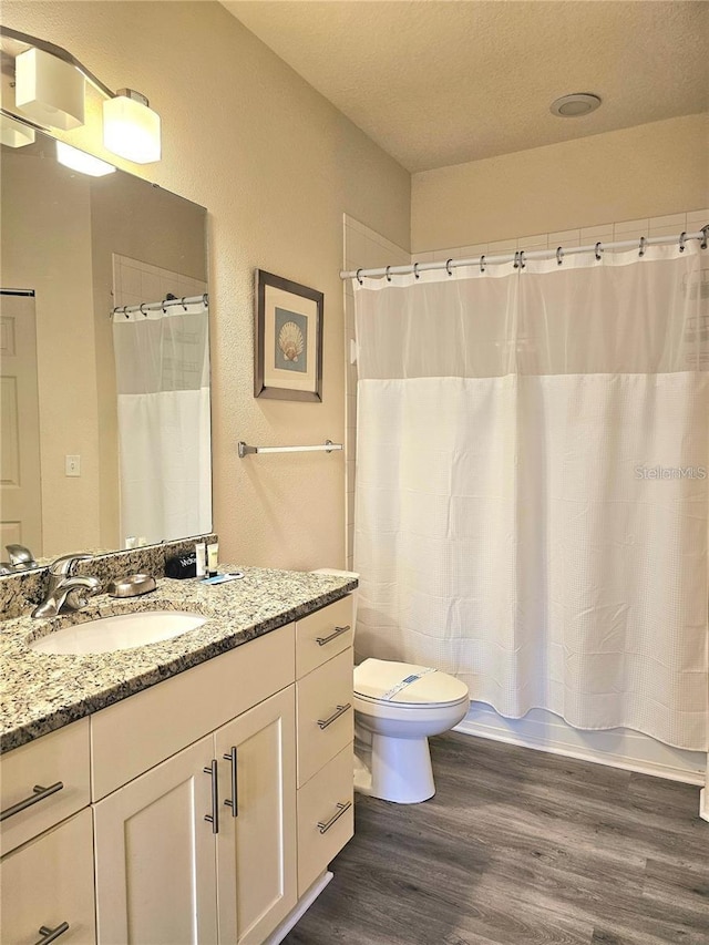 full bathroom with toilet, vanity, shower / bathtub combination with curtain, and wood finished floors