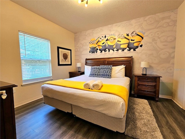 bedroom featuring baseboards, a textured ceiling, wallpapered walls, and wood finished floors