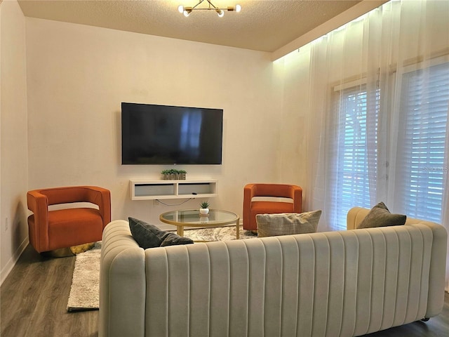 living area featuring radiator heating unit, a textured ceiling, baseboards, and wood finished floors
