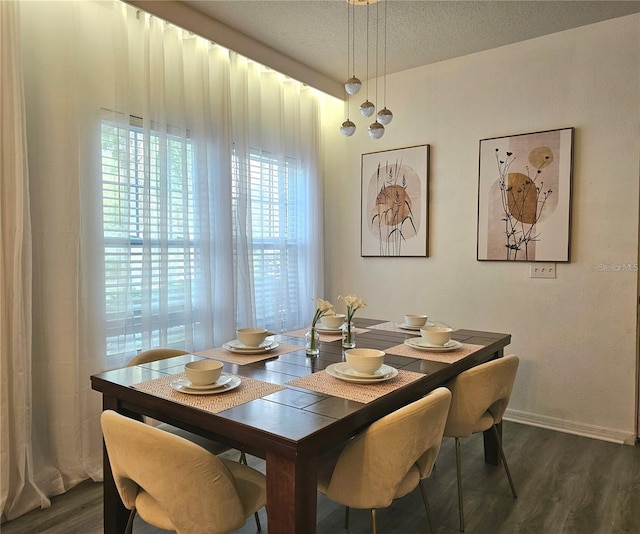 dining area with dark wood-type flooring, a textured ceiling, and baseboards