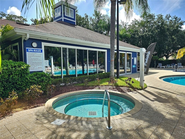 pool with a community hot tub and a patio area