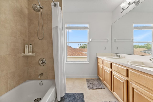 full bath featuring double vanity, a sink, and a healthy amount of sunlight