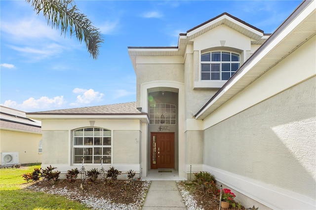239 Longhirst Loop, Ocoee, FL 34761 - view of exterior entry featuring stucco siding and a shingled roof