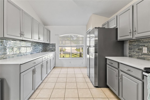 239 Longhirst Loop, Ocoee, FL 34761 - kitchen featuring gray cabinetry, light tile patterned floors, light countertops, decorative backsplash, and vaulted ceiling
