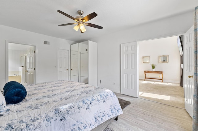 239 Longhirst Loop, Ocoee, FL 34761 - bedroom with light wood-type flooring, a ceiling fan, and ensuite bathroom