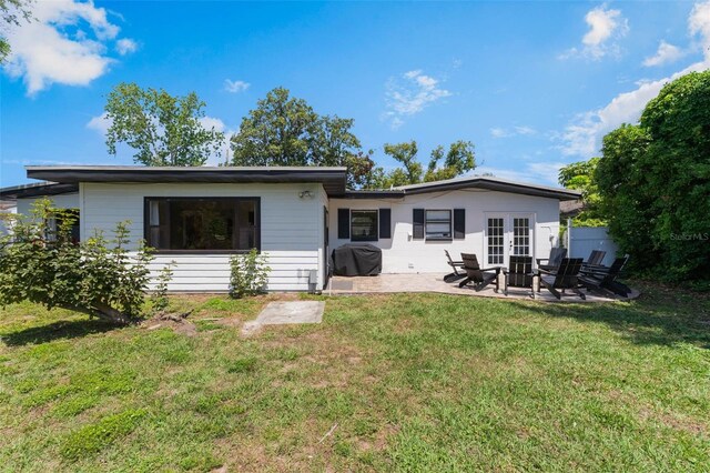 3204 Tradewinds Trl, Orlando, FL 32805 - back of property with a patio area, french doors, and a lawn