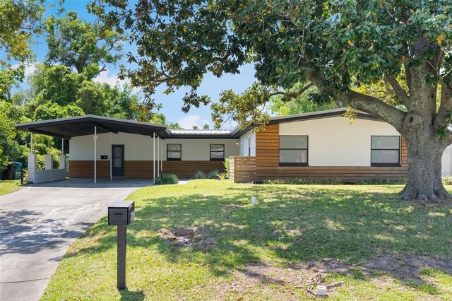3204 Tradewinds Trl, Orlando, FL 32805 - view of front of house featuring concrete driveway, a front lawn, and a carport