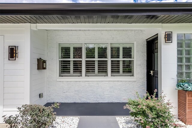 view of exterior entry with brick siding