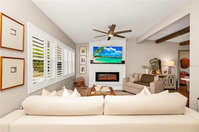 living room featuring a fireplace, ceiling fan, and beamed ceiling