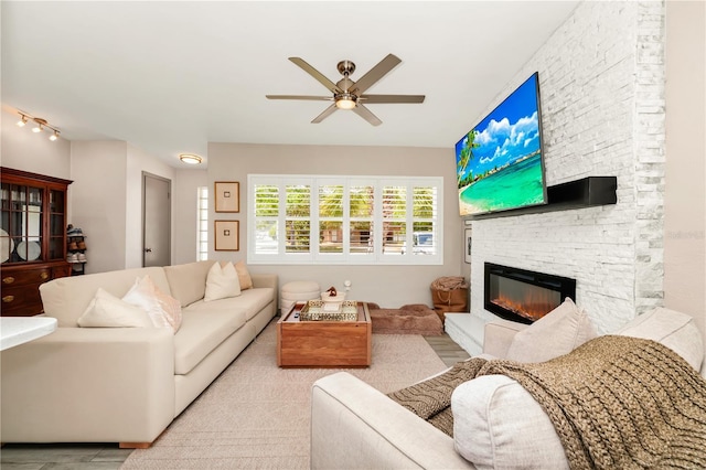 living area with a fireplace and ceiling fan