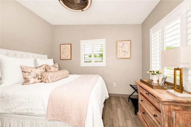 bedroom with baseboards and wood finished floors