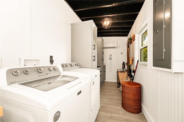 laundry area with laundry area, wood finish floors, electric panel, and washer and clothes dryer