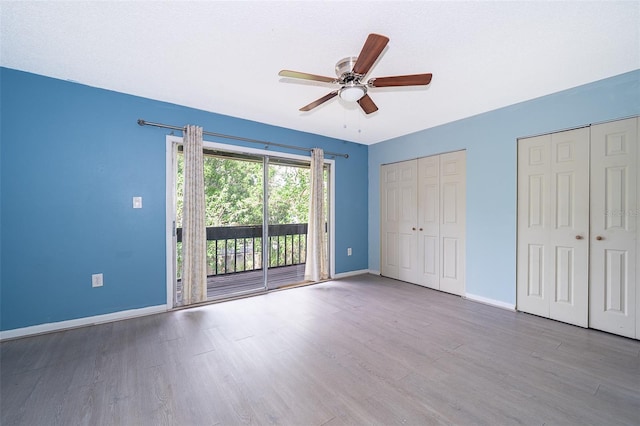 5060 Downing St Unit 6, Orlando, FL 32839 - unfurnished bedroom with access to outside, baseboards, two closets, and wood finished floors