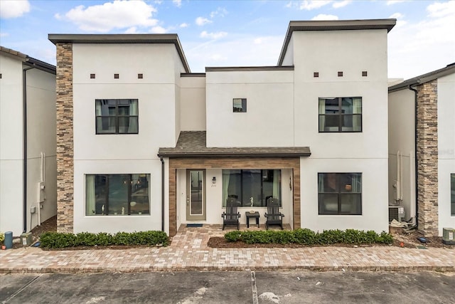 235 Villa Domani Cir, Davenport, FL 33896 - view of property with stucco siding, stone siding, and uncovered parking