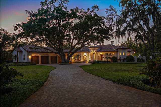 3412 Lilas Ct, Windermere, FL 34786 - mediterranean / spanish-style home featuring curved driveway, stucco siding, and a front lawn