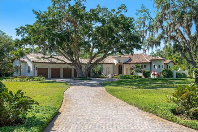 3412 Lilas Ct, Windermere, FL 34786 - mediterranean / spanish house with curved driveway, a garage, a front lawn, and stucco siding