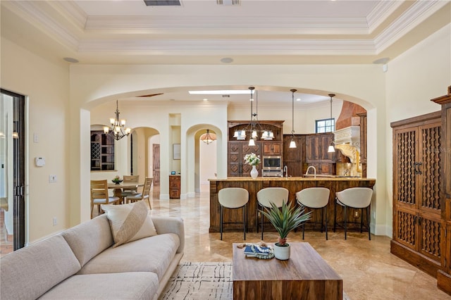 3412 Lilas Ct, Windermere, FL 34786 - living area with crown molding, a tray ceiling, arched walkways, visible vents, and a notable chandelier