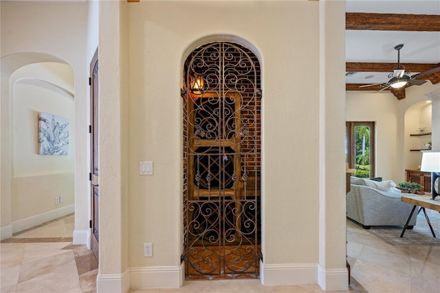 3412 Lilas Ct, Windermere, FL 34786 - wine area featuring beamed ceiling, arched walkways, a ceiling fan, tile patterned flooring, and baseboards