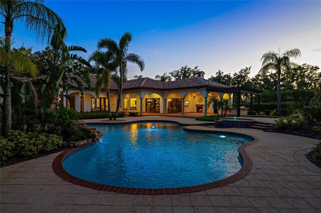 3412 Lilas Ct, Windermere, FL 34786 - pool at dusk with a patio area and a pool with connected hot tub