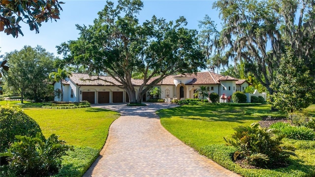 3412 Lilas Ct, Windermere, FL 34786 - mediterranean / spanish-style home featuring a garage, stucco siding, a front lawn, and decorative driveway