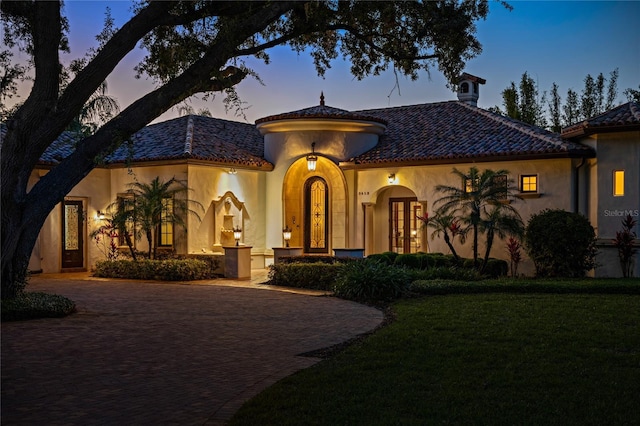 3412 Lilas Ct, Windermere, FL 34786 - mediterranean / spanish house featuring a front yard, french doors, a tiled roof, and stucco siding