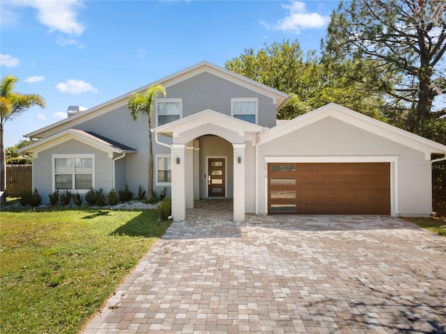 8616 Port Said St, Orlando, FL 32817 - view of front of property with a garage, stucco siding, decorative driveway, and a front lawn