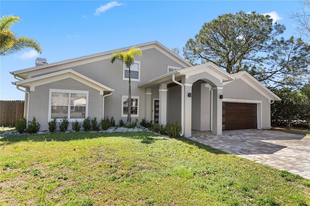 8616 Port Said St, Orlando, FL 32817 - traditional-style home featuring stucco siding, decorative driveway, fence, a front lawn, and a garage