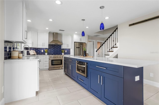 8616 Port Said St, Orlando, FL 32817 - kitchen featuring tasteful backsplash, a sink, wall chimney range hood, appliances with stainless steel finishes, and white cabinetry