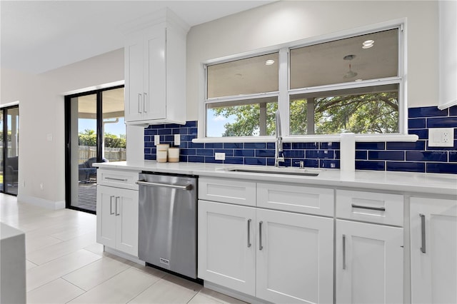 8616 Port Said St, Orlando, FL 32817 - kitchen with light countertops, backsplash, white cabinets, dishwasher, and a sink