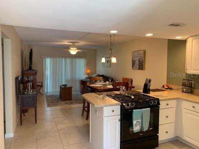 325 N Causeway Unit D104, New Smyrna Beach, FL 32169 - kitchen with light countertops, black gas stove, visible vents, white cabinets, and a peninsula
