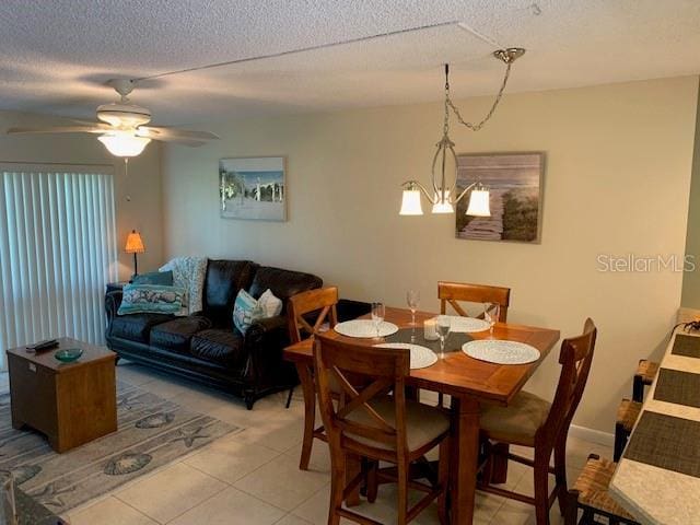 325 N Causeway Unit D104, New Smyrna Beach, FL 32169 - dining room with light tile patterned floors, a textured ceiling, and ceiling fan with notable chandelier