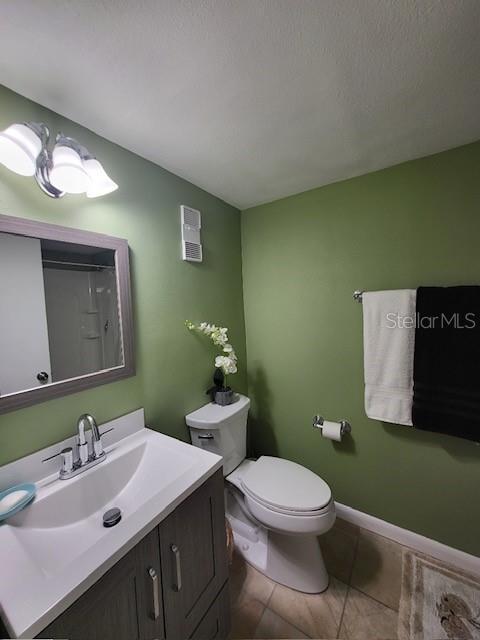 325 N Causeway Unit D104, New Smyrna Beach, FL 32169 - full bath with toilet, vanity, tile patterned floors, and baseboards