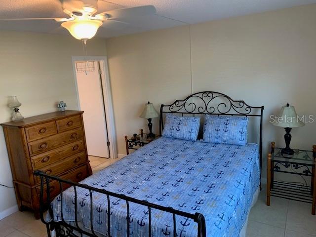 325 N Causeway Unit D104, New Smyrna Beach, FL 32169 - bedroom with a ceiling fan and light tile patterned floors