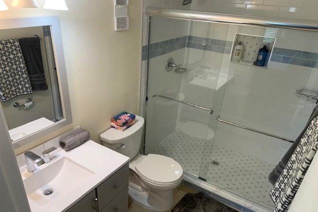 325 N Causeway Unit D104, New Smyrna Beach, FL 32169 - bathroom featuring toilet, vanity, and a stall shower