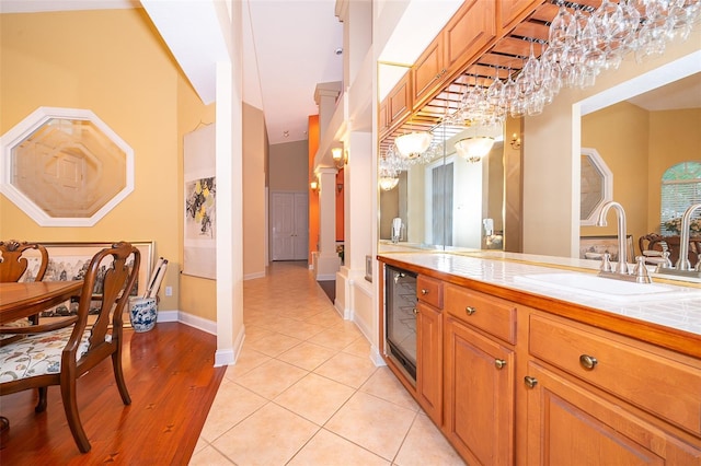 1709 Iverness Ct, Longwood, FL 32779 - kitchen with wine cooler, a sink, brown cabinets, tile countertops, and a towering ceiling