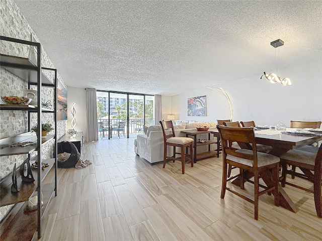 1581 Gulf Blvd Unit 102N, Clearwater Beach, FL 33767 - dining area featuring a wall of windows, a textured ceiling, light wood finished floors, and a chandelier