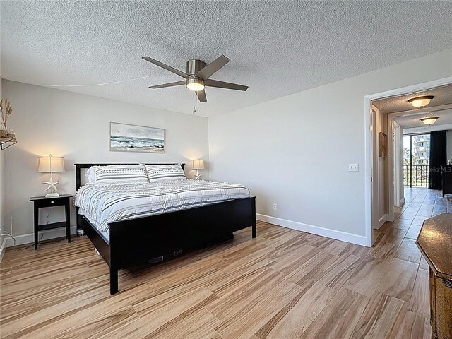 1581 Gulf Blvd Unit 102N, Clearwater Beach, FL 33767 - bedroom with light wood-type flooring, baseboards, a textured ceiling, and a ceiling fan