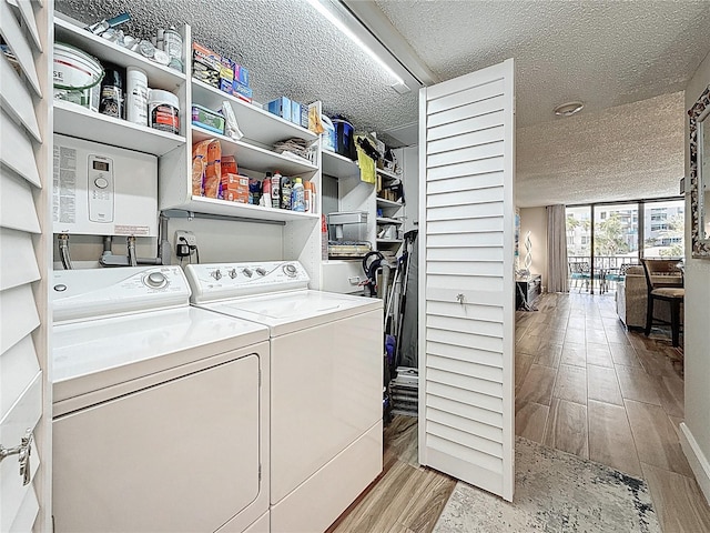 1581 Gulf Blvd Unit 102N, Clearwater Beach, FL 33767 - laundry room with washing machine and clothes dryer, a textured ceiling, and wood finished floors